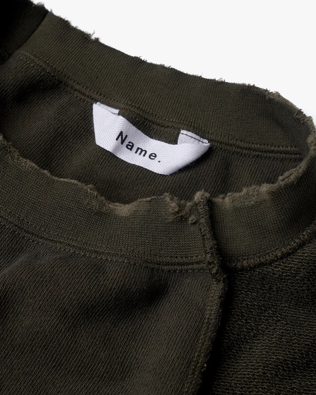 Name. EDGE AGING ASYMMETRIC SWEATSHIRT OLIVE ネーム スウェット ダメージ 正規取扱店 公式通販 送料無料